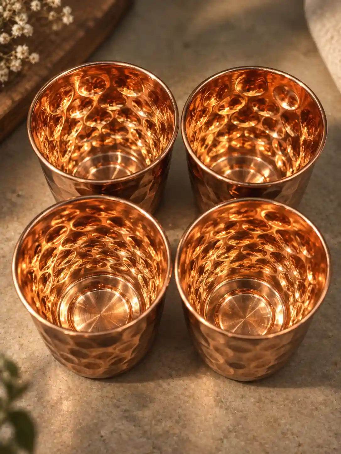 Top view of four diamond hammered pure copper water glasses showing the unlined copper interiors