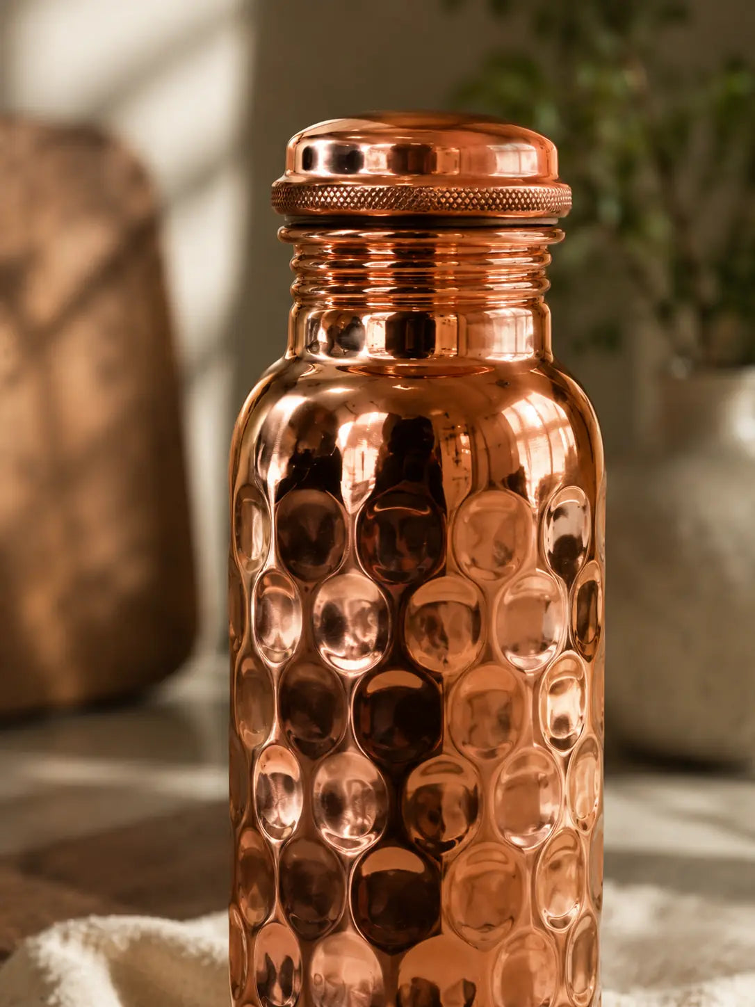 Close-up of the Cupreva Diamond Hammered Pure Copper Water Bottle in a luxury home