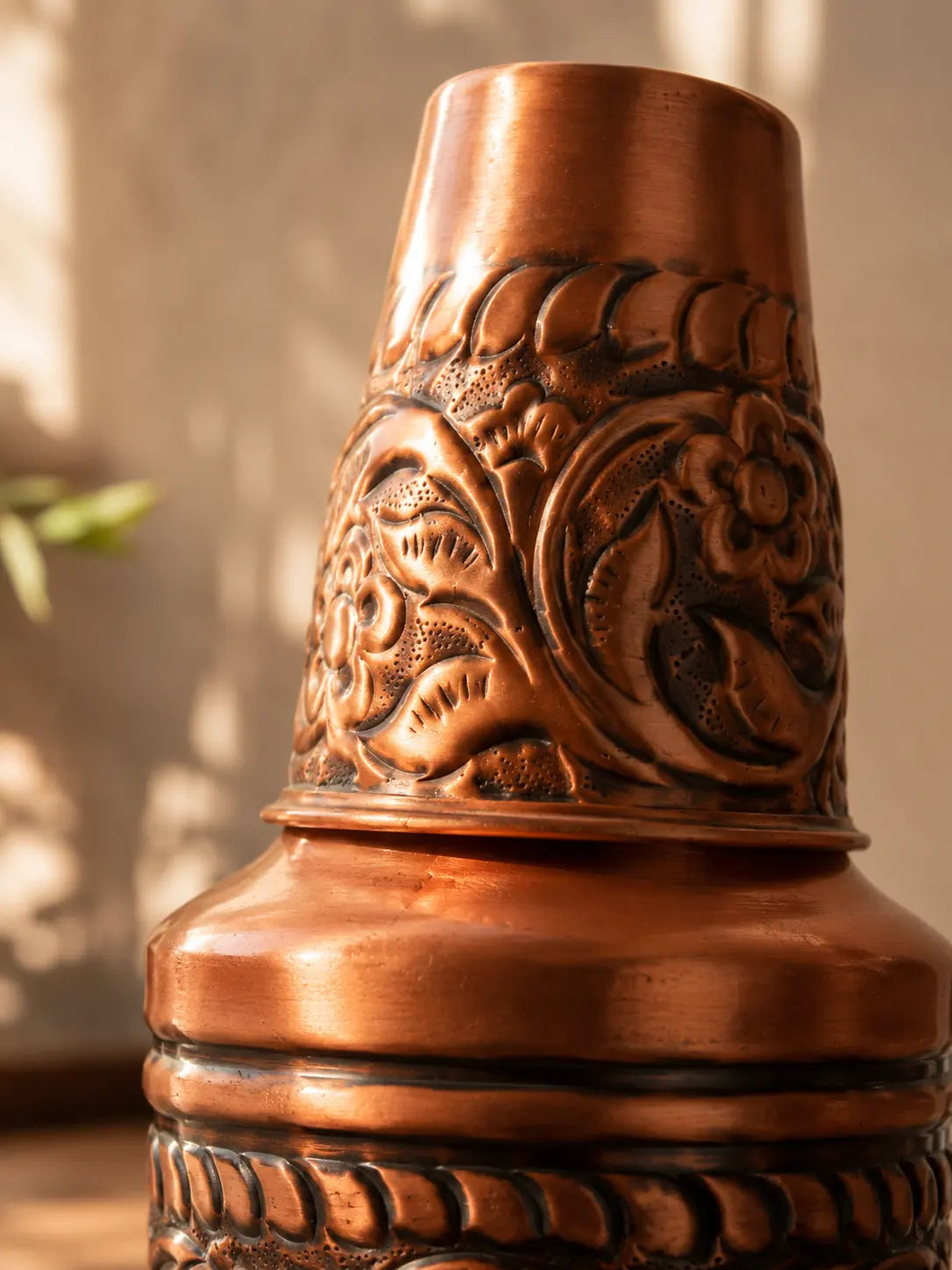 Close-up of embossed floral detailing on a handcrafted pure copper water carafe