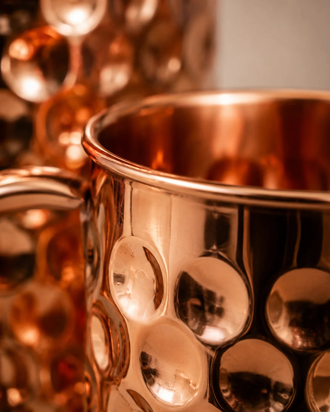 Close-up of a handcrafted hammered pure copper drinking glass highlighting its polished finish and premium texture.