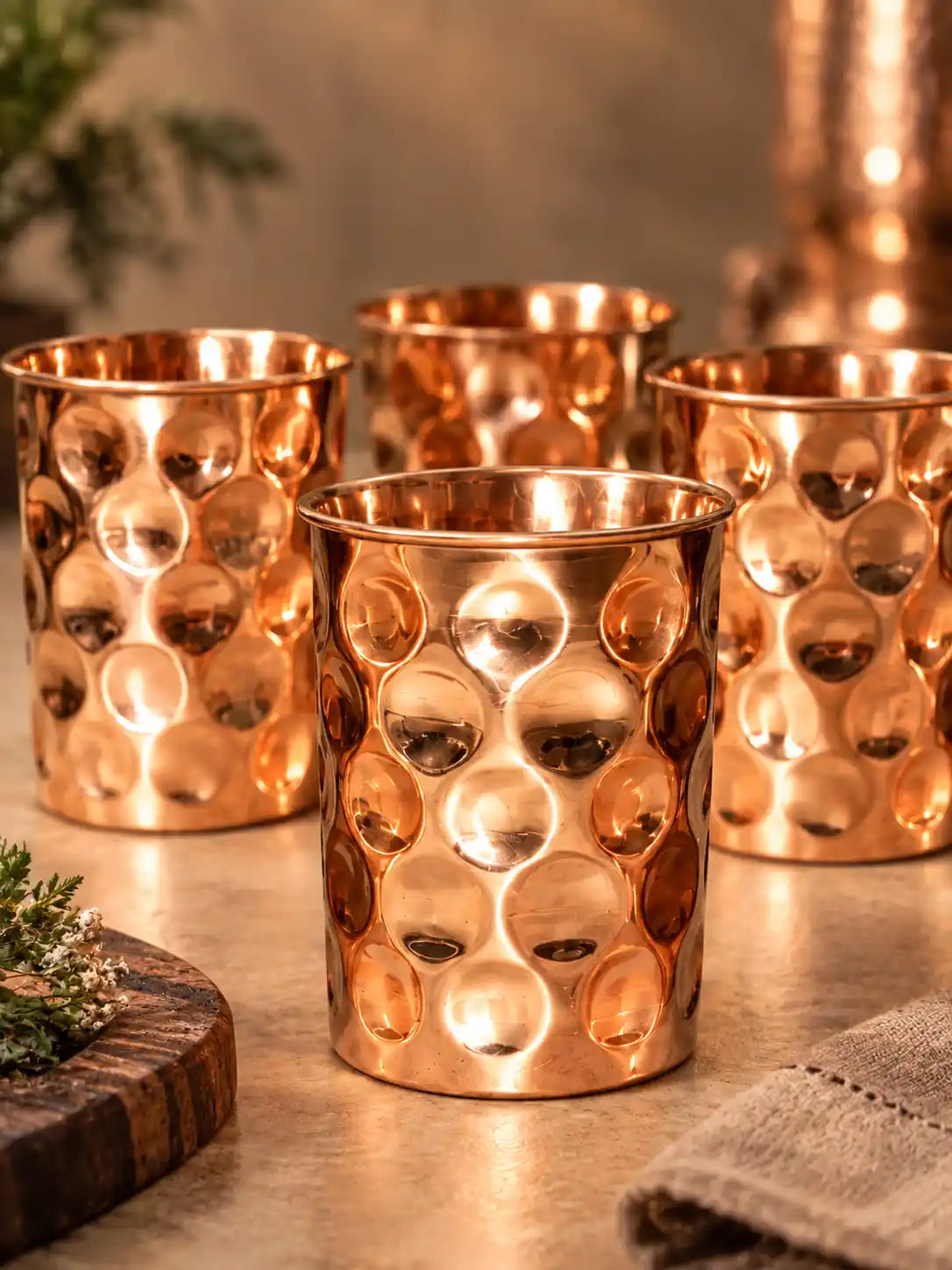 Handcrafted diamond hammered copper water glasses in a premium tabletop setting