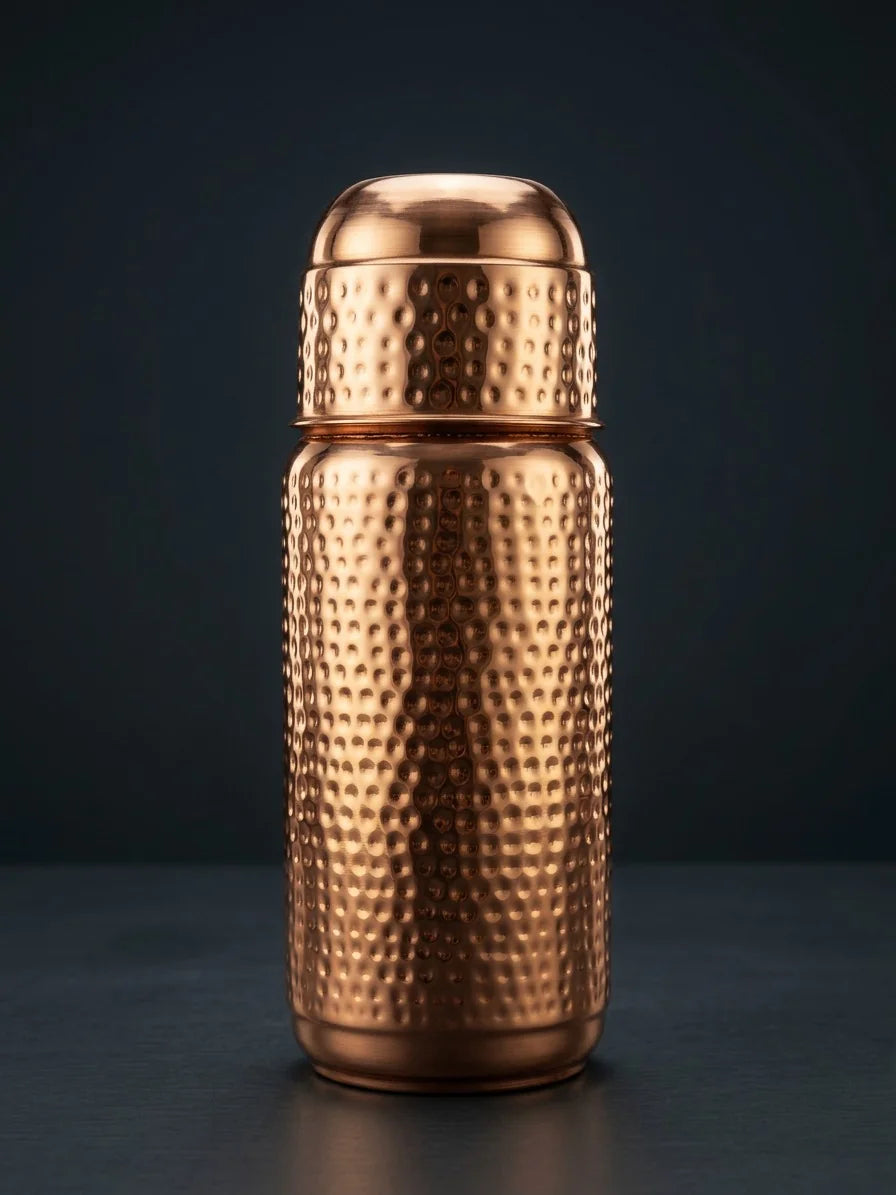 Premium hammered copper water bottle with reflective polished finish on dark background