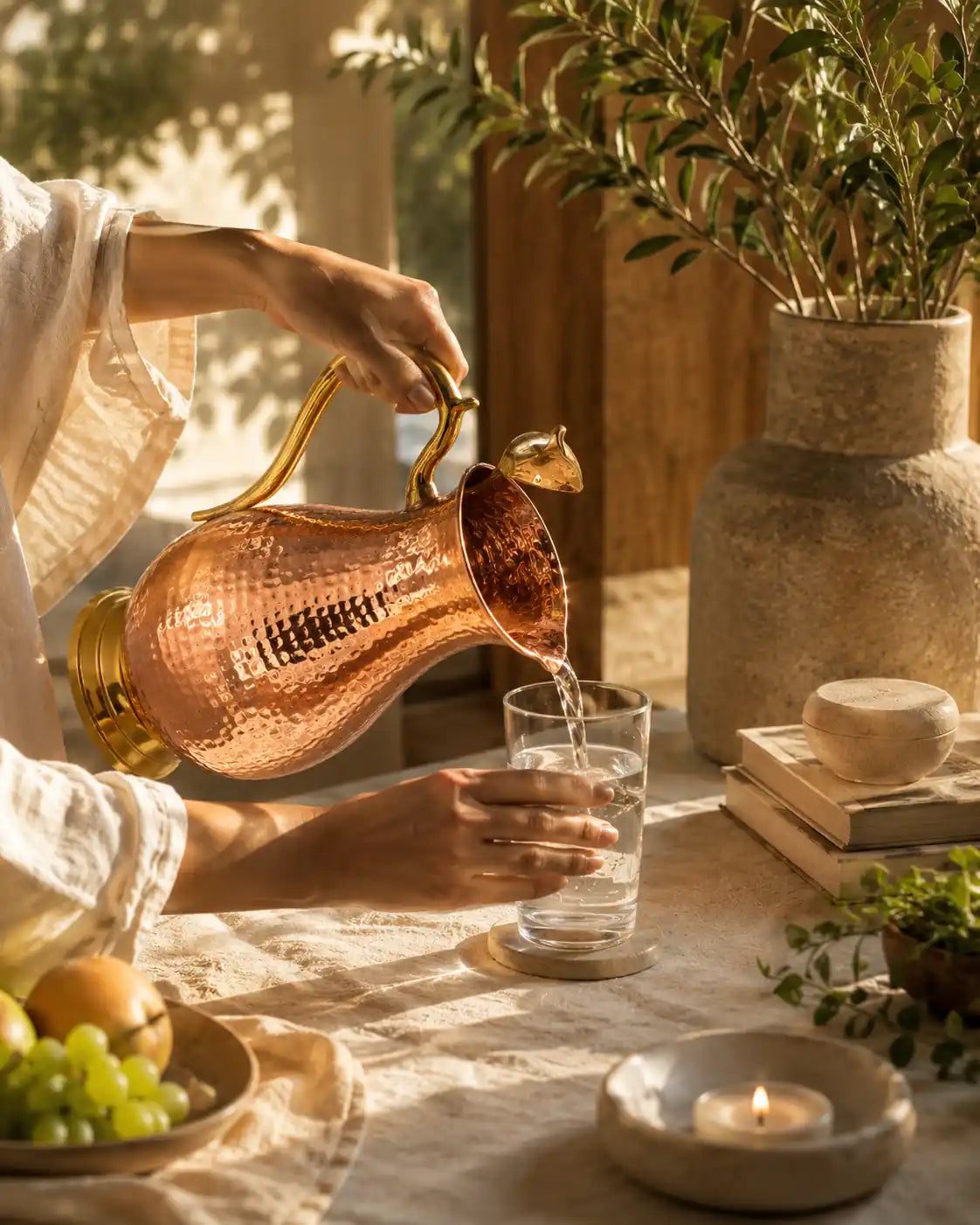Pouring water from a handcrafted pure copper pitcher into a drinking glass