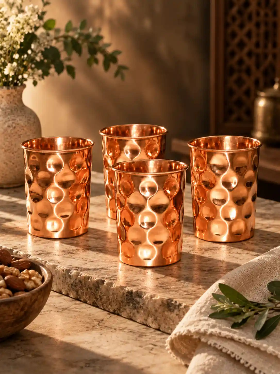 Premium editorial arrangement of four diamond hammered pure copper water glasses
