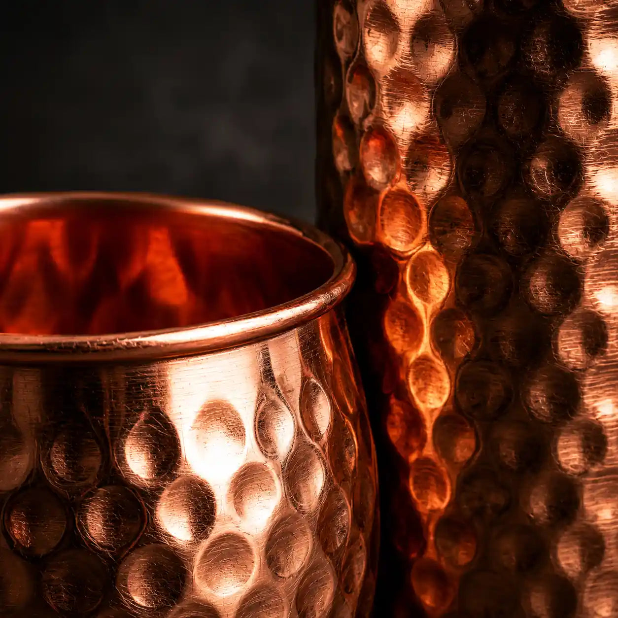 Copper candle holder with textured surface on a dark background